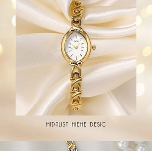 Détail de la montre dorée GEDI avec bracelet chaîne sur un tissu satiné crème luxueux