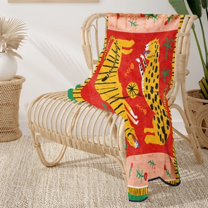 Detail of artistic illustration on a red tiger pattern soft flannel blanket on a chair