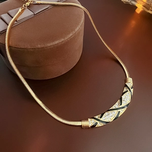 Makroaufnahme der Vintage-Goldkette mit schwarzer Emaille und funkelnden Diamanten