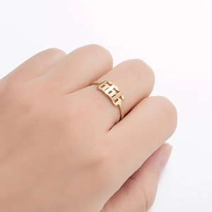 Close-up of gold gothic 666 angel number ring on model hand with cut-out design