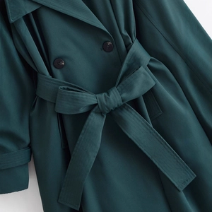 Elegant dark green double-breasted trench coat with waist belt and button details