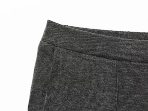 Detailed macro shot of dark grey ribbed knit pants showing waist and side seam texture
