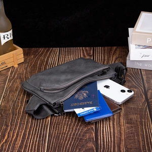 Detail showing the large storage capacity and dual zippers of the dark grey matte sling bag