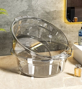 Close-up of stacked clear PET washbasins with ergonomic handles on bathroom counter