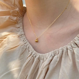 Minimalist gold 925 sterling silver necklace with key pendant on woman's neckline