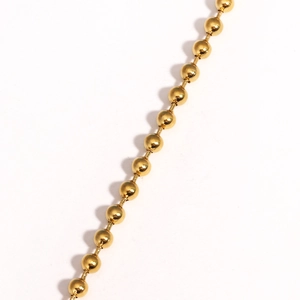 Dettaglio del bracciale con catena a sfere placcato oro 18K e riflessi metallici