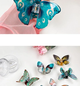 Detailed macro view of colorful acrylic butterfly hair claws with bionic wing patterns