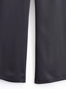 Close-up of black trousers showing high-quality stitching and matte fabric texture