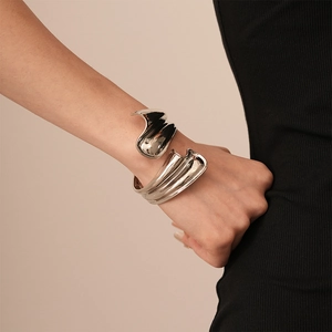 Macro view of silver sculptural wide cuff bracelet with a polished mirror finish