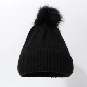 Thick black ribbed knit beanie with large faux fur pompom for winter outdoor warmth