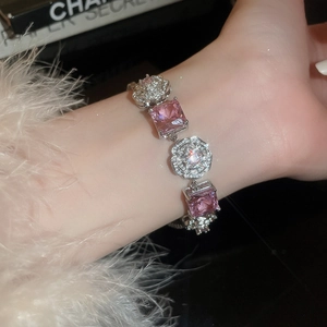 Detail of flower shaped zircon and pink square gemstone bracelet on wrist
