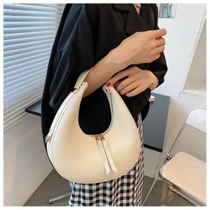 Chic beige crescent hobo shoulder bag styled with a minimalist outfit and black skirt