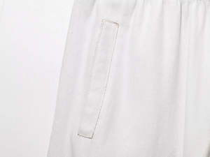 Vue détaillée de la couture de la poche sur le pantalon jogging blanc en denim
