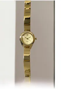 Close-up of champagne gold bangle watch with polished mirror finish and Roman numeral dial