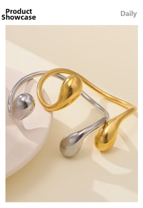 Dettaglio dei bracciali rigidi a goccia in oro e argento lucidi dal design minimalista