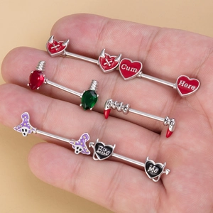 Industrial barbell body jewelry featuring devil hearts and lettered charms on steel bars