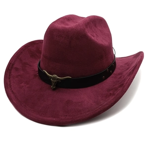 Detail of burgundy suede cowboy hat with black leather band and metal bull head emblem