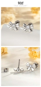 Detail of silver bow earrings with screw back studs and sparkling central zircon stones