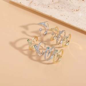 Macro shot of assorted zircon-studded snake, whale tail, and bolt rings on stone decoration