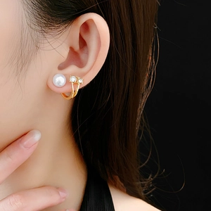Gros plan de boucles d'oreilles élégantes en perles dorées et strass sur un modèle