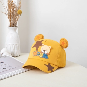 Détail de la casquette de baseball jaune pour enfants avec oreilles d'ours et broderie