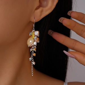 Detail of vintage bohemian tassel earrings with champagne frosted beads and gold leaves