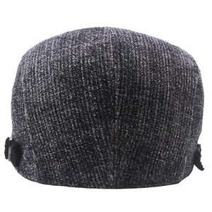 Détail de la texture tricotée et de la boucle argentée au dos du béret rayé
