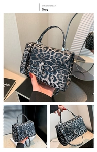 Detail view of grey leopard print handbag with metallic buckle and adjustable strap