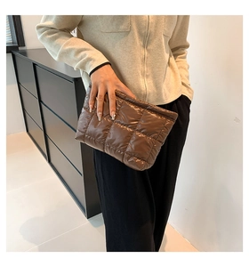 Detailansicht der braunen gesteppten Clutch aus glänzendem Nylon mit weicher Karostruktur