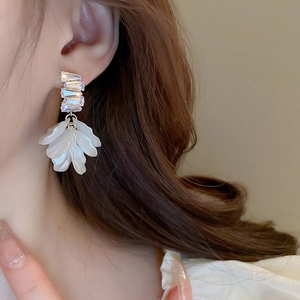 Detail of shell flower tassel earrings with rectangular zircon on elegant model