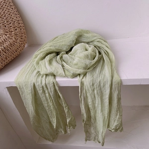 Detail of light green pleated scarf with vintage texture on white background