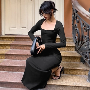 Détail d'une robe longue noire moulante avec col carré et manches longues élégantes