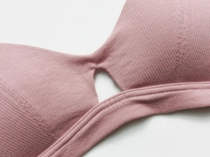 Close-up of ribbed rose pink bralette showing reinforced stitching and hollow-out detail