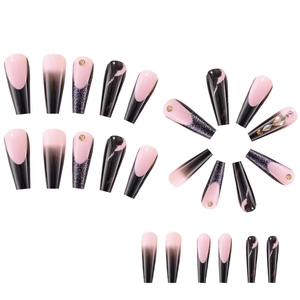 Detailed view of long French ombre press-on nails with pink, black, and rhinestone accents