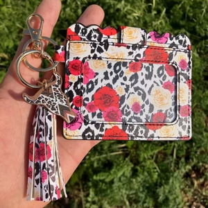 Leopard print card holder with floral pattern, tassel, and cow head charm pendant