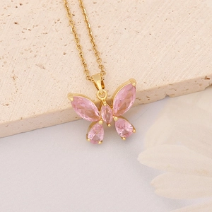 Elegant gold necklace featuring a pink butterfly pendant over minimalist neutral background
