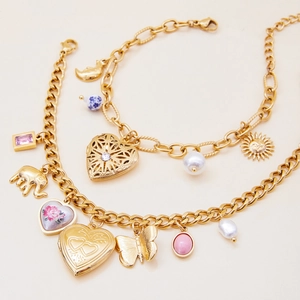 Close-up of vintage gold multilayer bracelets with heart locket and elephant charms