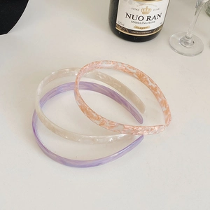 Detailed macro view of acetate headbands in pink, purple, and white marble textures