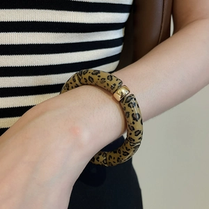 Detailed close-up of leopard print resin beads bracelet with a gold metal bead accent