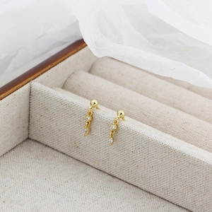 Macro detail of gold S925 silver long drop earrings with shiny diamond screw back design