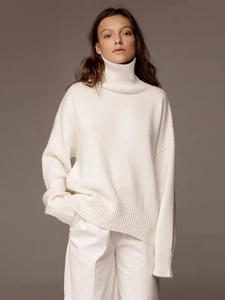 Détail d'un pull à col montant blanc avec texture en maille de laine et éclairage doux