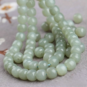 Close-up of light green Hetian jade beads with a smooth polished oily finish for DIY jewelry