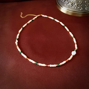 Detail of colorful beads with gold lobster clasp and extension chain on a necklace