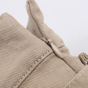 Vista macro della gonna midi kaki con cerniera invisibile e trama in cotone twill fine
