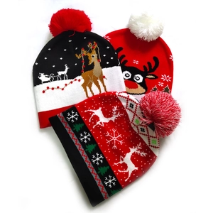 Detailed knit patterns of reindeer and snowflake on festive Christmas beanies with pom poms
