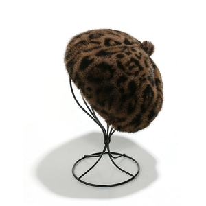 Faux mink fur leopard print beret hat for women on a display stand in studio lighting
