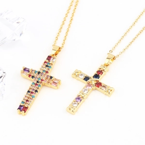 Detailed view of two gold cross necklaces with colorful micro-pave crystals