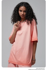 Detail showing the acid wash texture and coral pink fabric of an oversized vintage T-shirt