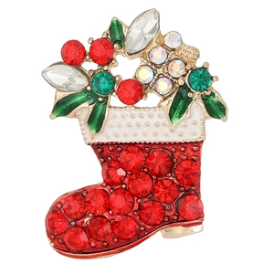 Detailed view of Christmas stocking brooch with red rhinestones and enamel leaves