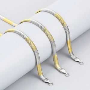 Three-piece set of two-tone stainless steel flat snake bone necklaces on a grey display